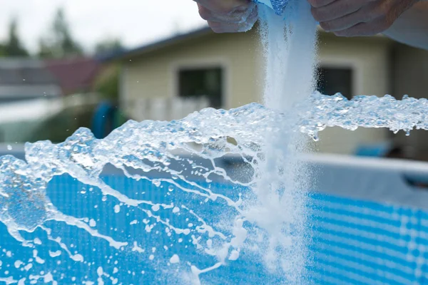 Adam ev havuzundaki deniz tuzunu tamamlıyor..