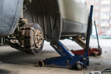 detay tekerlek derleme üzerinde modern bir otomobil. ağız açık rotor ve Kaliper gösterilen kaldırılır.