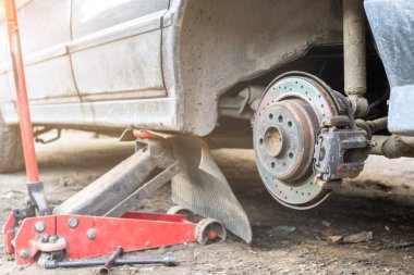 detay tekerlek derleme üzerinde modern bir otomobil. ağız açık rotor ve Kaliper gösterilen kaldırılır.