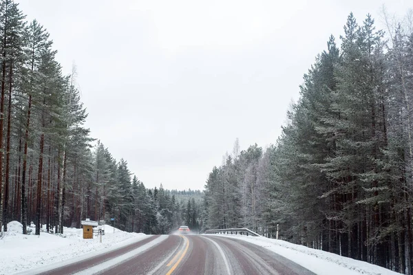 雪の覆われた道路上のライトが付いている車 — ストック写真