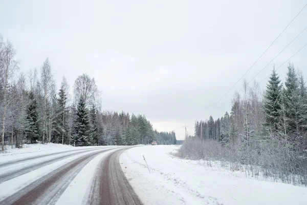 雪の覆われた道路上のライトが付いている車 — ストック写真