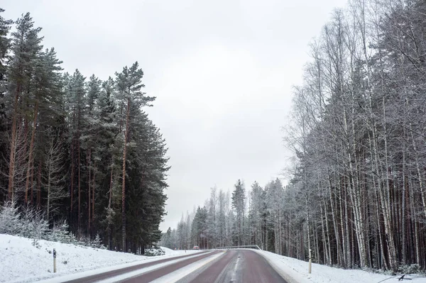 雪の覆われた道路上のライトが付いている車 — ストック写真