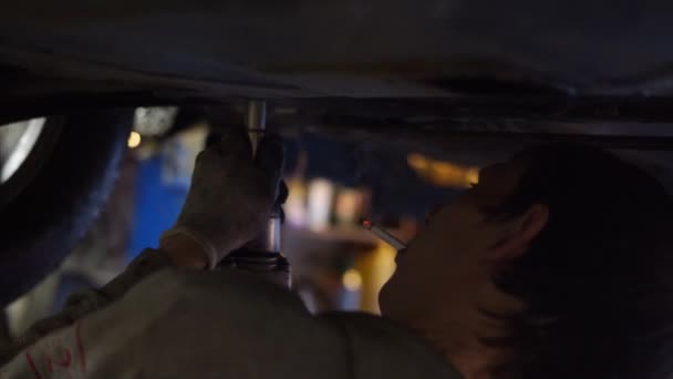 Μηχανικός Ξεβιδώνει Προστασία Κάτω Από Αυτοκίνητο — Αρχείο Βίντεο