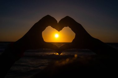 Sahilde gün batımı sırasında kalp şeklinde el Falasarne, Yunanistan, Girit