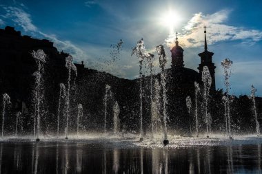 Çocuklar sıcak bir günde kuru bir çeşme içinde eğlenin