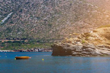 Deniz kenarında bir kaya üzerinde şezlong
