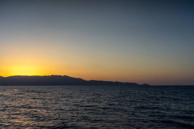 Gün batımında kaya groyne, Girit, Yunanistan