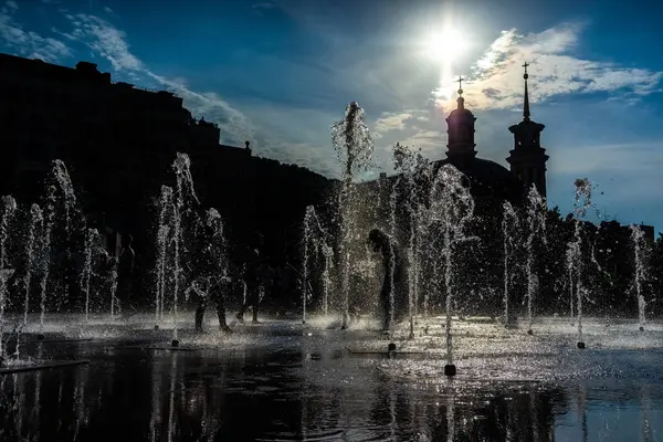 Çocuklar sıcak bir günde kuru bir çeşme içinde eğlenin