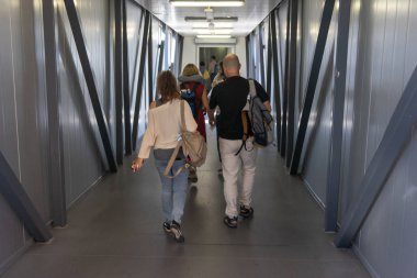 Rusya, Moskova, Ağustos 2018: Teleskopik geçitin içindeki koridorda giden insanlar