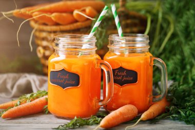 Taze havuç ve havuç suyu bahçe ahşap tablo. Sebze vitaminler Keratin. Doğal organik havuç ahşap arka plan üzerinde yatıyor.