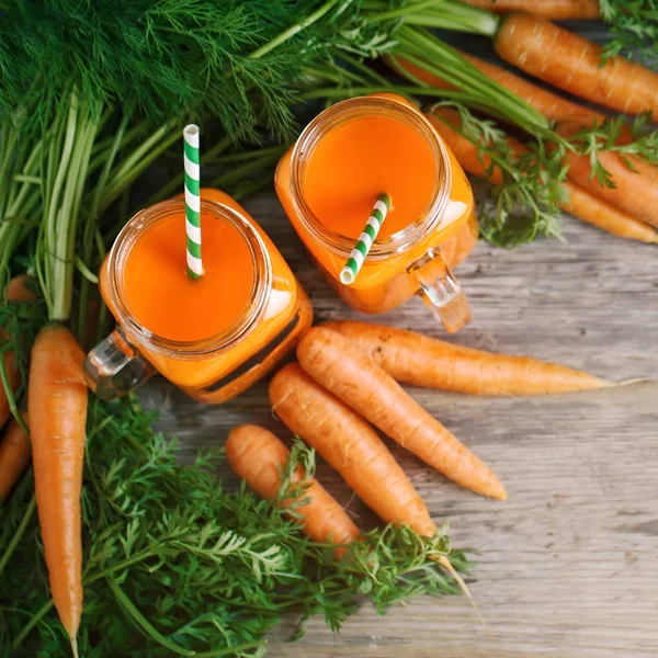 Taze havuç ve havuç suyu bahçe ahşap tablo. Sebze vitaminler Keratin. Doğal organik havuç ahşap arka plan üzerinde yatıyor.