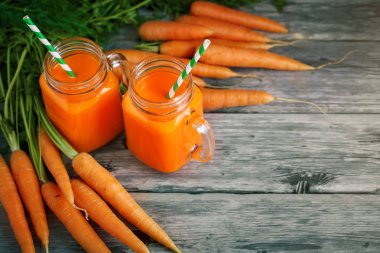 Taze havuç ve havuç suyu bahçe ahşap tablo. Sebze vitaminler Keratin. Doğal organik havuç ahşap arka plan üzerinde yatıyor.