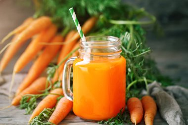 Taze havuç ve havuç suyu bahçe ahşap tablo. Sebze vitaminler Keratin. Doğal organik havuç ahşap arka plan üzerinde yatıyor.