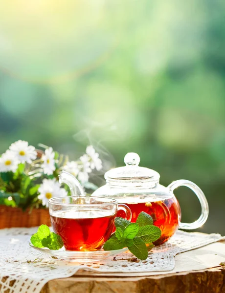 Cup met hete thee met munt en een tijm op een houten tafel in een zomertuin. Selectieve aandacht, — Stockfoto