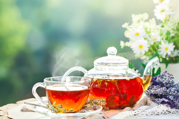 Cup met hete thee met munt en een tijm op een houten tafel in een zomertuin. Selectieve aandacht, — Stockfoto