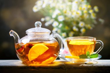 Taze demlendi siyah çay, sıcak yumuşak ışık, koyu arka plan.