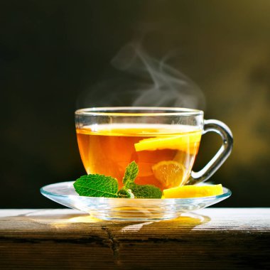 Taze demlendi siyah çay, sıcak yumuşak ışık, koyu arka plan.