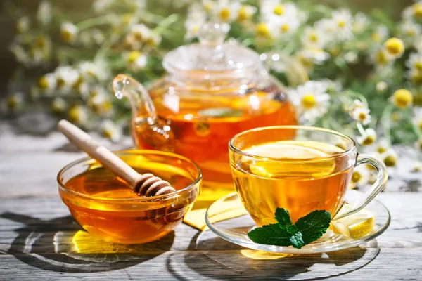 Tasse mit heißem Tee mit Minze und Thymian auf einem Holztisch im Sommergarten. — Stockfoto