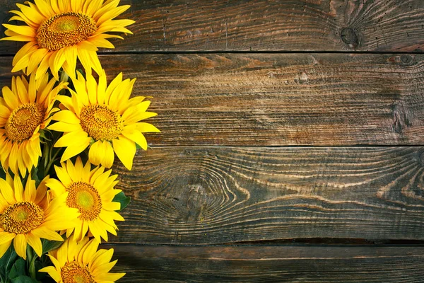 stock image Beautiful sunflowers on a wooden table. View from above. Background with copy space.