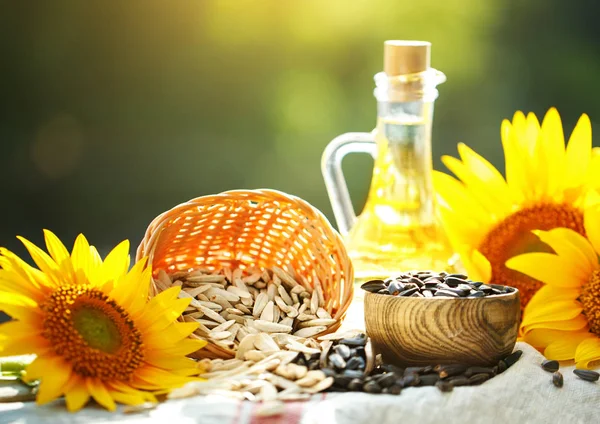 Foto de primer plano de girasoles y aceite de girasol con semillas sobre una mesa de madera. Concepto bio y orgánico del producto . — Foto de Stock