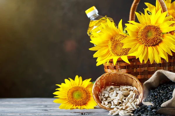 Foto de close-up de girassóis e óleo de girassol com sementes em uma mesa de madeira. Bio e conceito orgânico do produto . — Fotografia de Stock