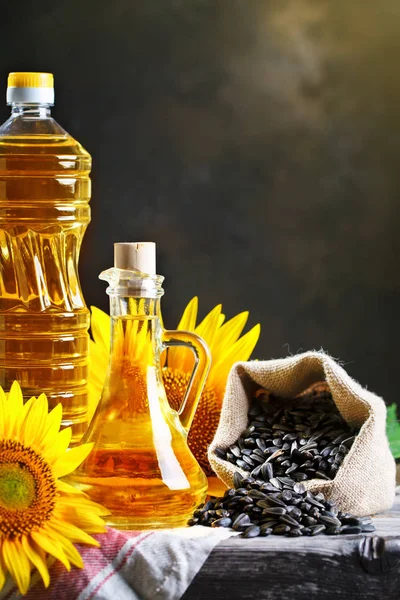 Foto de close-up de girassóis e óleo de girassol com sementes em uma mesa de madeira. Bio e conceito orgânico do produto . — Fotografia de Stock
