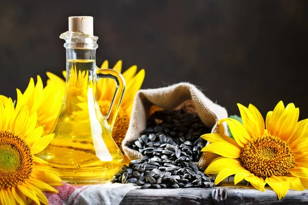 Nahaufnahme Foto von Sonnenblumen und Sonnenblumenöl mit Samen auf einem Holztisch. Bio-und Bio-Konzept des Produkts. — Stockfoto