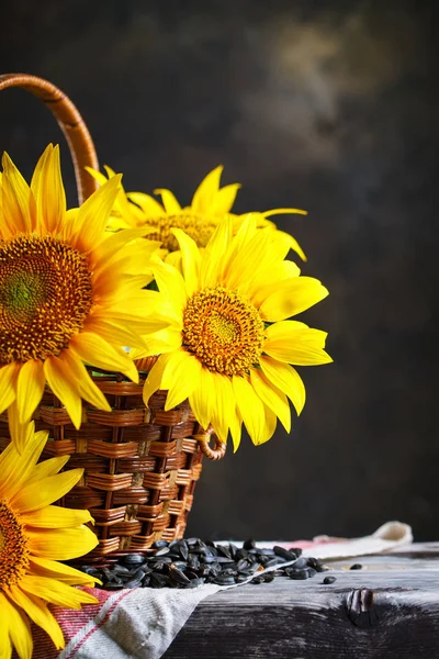 Hermosos girasoles en una canasta sobre una mesa de madera . — Foto de Stock