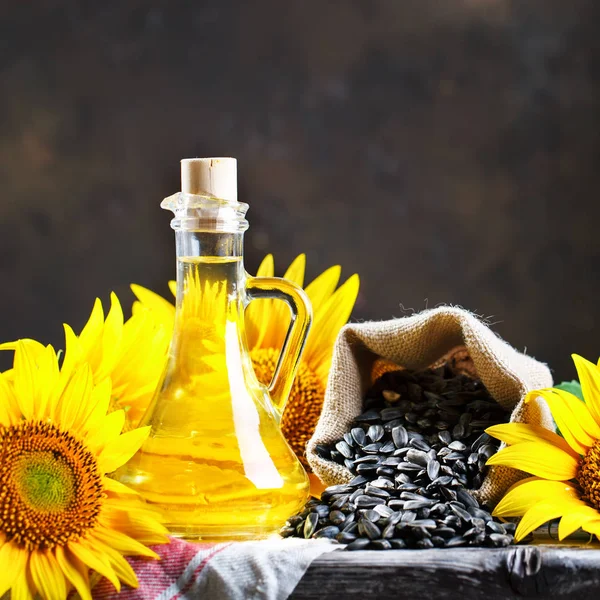 Foto de primer plano de girasoles y aceite de girasol con semillas sobre una mesa de madera. Concepto bio y orgánico del producto . — Foto de Stock
