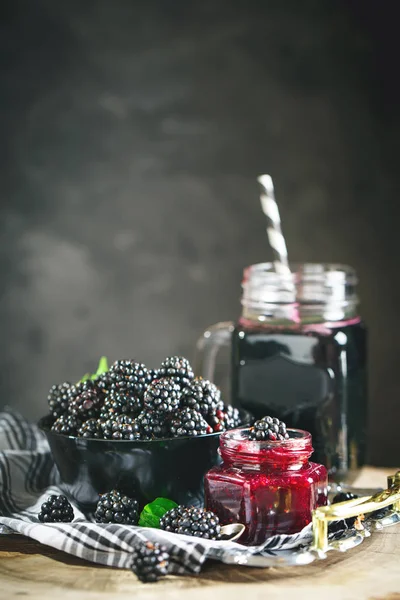 Ripe blackberry, blackberry juice and jam on a wooden table. Dark background. — Stock Photo, Image