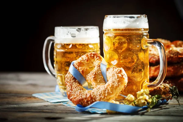 Bierpullen en pretzels op een houten tafel. Oktoberfest. Bierfestival. — Stockfoto