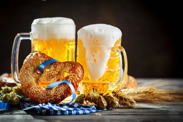 Bierpullen en pretzels op een houten tafel. Oktoberfest. Bierfestival. — Stockfoto