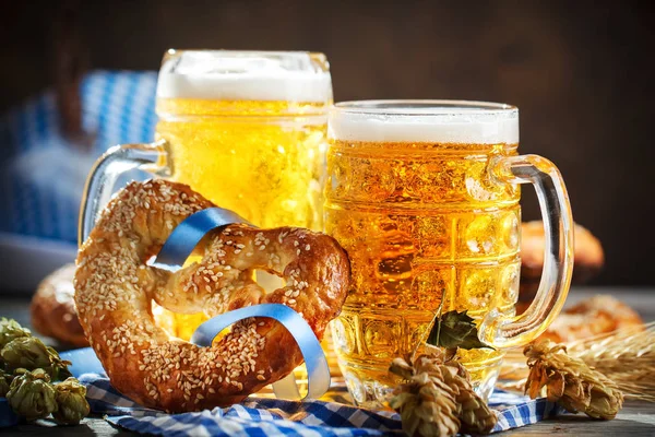 Beer mugs and pretzels on a wooden table. Oktoberfest. Beer festival.