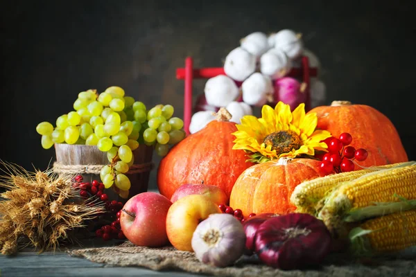 Деревянный стол, украшенный тыквой, кукурузой, фруктами и осенними листьями. Праздник урожая. Выборочный фокус. Горизонталь . — стоковое фото