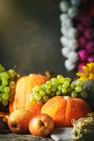 Happy Thanksgiving Day background, wooden table decorated with Pumpkins, Maize, fruits and autumn leaves. Harvest festival. Selective focus. Vertical. Background with copy space.