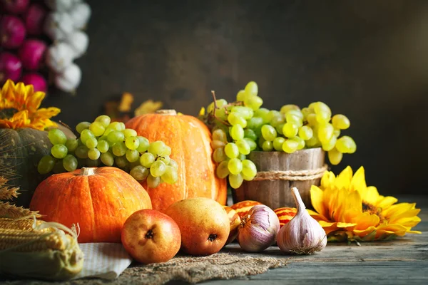 Happy Thanksgiving Day background, wooden table decorated with Pumpkins, Maize, fruits and autumn leaves. Harvest festival. Selective focus. Horizontal. Background with copy space.