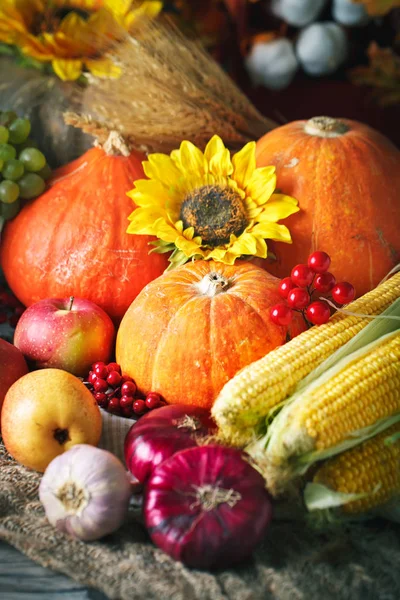 Happy Thanksgiving Day achtergrond, houten tafel versierd met pompoenen, maïs, fruit en herfstbladeren. Oogstfeest. Selectieve aandacht. Verticaal. — Stockfoto