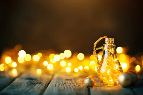 God jul och gott nytt år. Christmas garland i en glasburk på ett träbord. Selektivt fokus. — Stockfoto