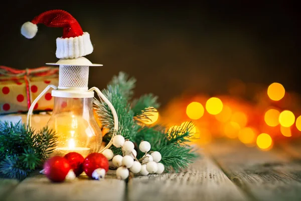 God jul och gott nytt år. Ljus och jul leksaker på ett träbord på bakgrunden av en krans. Bokeh. Selektivt fokus. Bakgrund med kopia utrymme. — Stockfoto