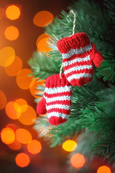 Feliz Navidad y feliz año nuevo. Pequeñas manoplas de punto en el árbol de Navidad. Fondo con espacio de copia . —  Fotos de Stock