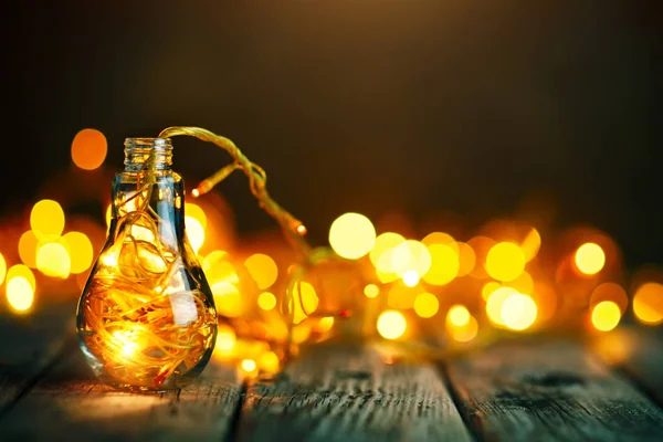 God jul och gott nytt år. Christmas garland i en glasburk på ett träbord. Selektivt fokus. — Stockfoto