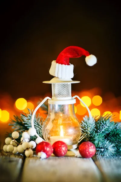 God jul och gott nytt år. Ljus och jul leksaker på ett träbord på bakgrunden av en krans. Bokeh. Selektivt fokus. Bakgrund med kopia utrymme. — Stockfoto