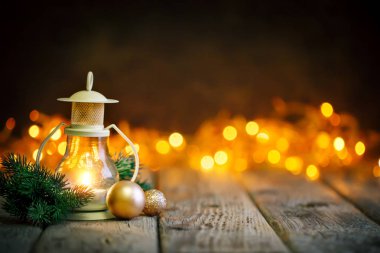 Mutlu Noeller ve mutlu yeni yıl. Çelenk arka plan üzerinde ahşap bir masa mum ve Noel oyuncaklar. Bokeh. Seçici odak. Arka plan kopya alanı ile.