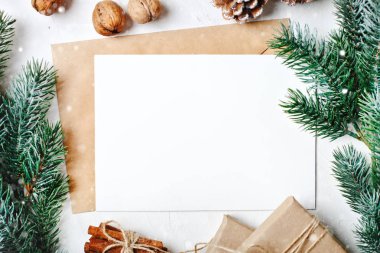 Mutlu Noeller ve mutlu yeni yıl. Mockup kartpostal ve beyaz arka plan üzerinde bir Noel ağacı dalları ile. Arka plan kopya alanı ile. Üstten görünüm. Noel arka plan. Yatay.