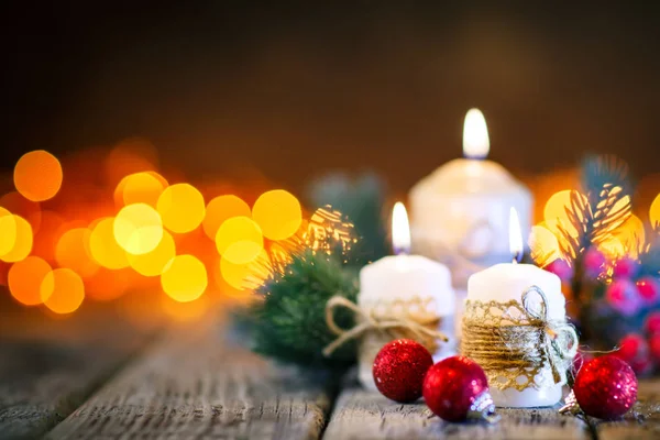 Καλά Χριστούγεννα και Ευτυχισμένο το νέο έτος. Κερί και χριστουγεννιάτικα παιχνίδια σε ένα ξύλινο τραπέζι για το ιστορικό της μια γιρλάντα. Bokeh. Επιλεκτική εστίαση. Φόντο με αντίγραφο χώρου. — Φωτογραφία Αρχείου