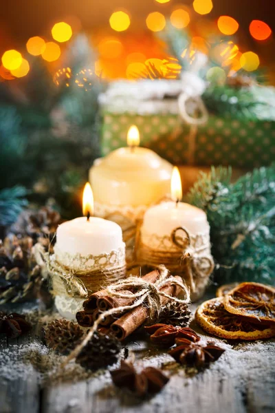 Καλά Χριστούγεννα και Ευτυχισμένο το νέο έτος. Κερί και χριστουγεννιάτικα παιχνίδια σε ένα ξύλινο τραπέζι. Bokeh. Επιλεκτική εστίαση. — Φωτογραφία Αρχείου