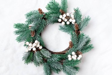 Mutlu Noeller ve mutlu yeni yıl. Hafif bir arka plan üzerinde Noel dekoratif çelenk. Arka plan kopya alanı ile. Üstten görünüm.