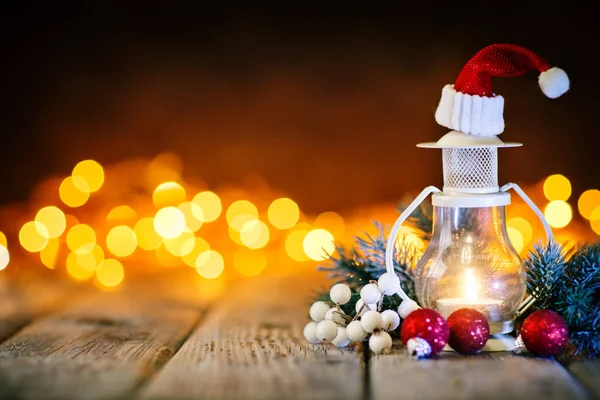 Καλά Χριστούγεννα και Ευτυχισμένο το νέο έτος. Κερί και χριστουγεννιάτικα παιχνίδια σε ένα ξύλινο τραπέζι για το ιστορικό της μια γιρλάντα. Bokeh. Επιλεκτική εστίαση. Φόντο με αντίγραφο χώρου. — Φωτογραφία Αρχείου