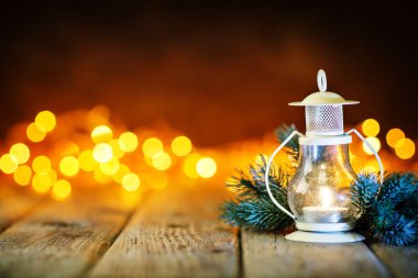 Mutlu Noeller ve mutlu yeni yıl. Çelenk arka plan üzerinde ahşap bir masa mum ve Noel oyuncaklar. Bokeh. Seçici odak. Arka plan kopya alanı ile.