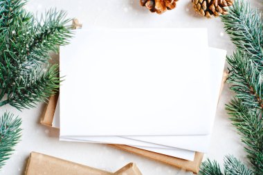 Mutlu Noeller ve mutlu yeni yıl. Mockup kartpostal ve beyaz arka plan üzerinde bir Noel ağacı dalları ile. Arka plan kopya alanı ile. Üstten görünüm. Noel arka plan. Yatay.